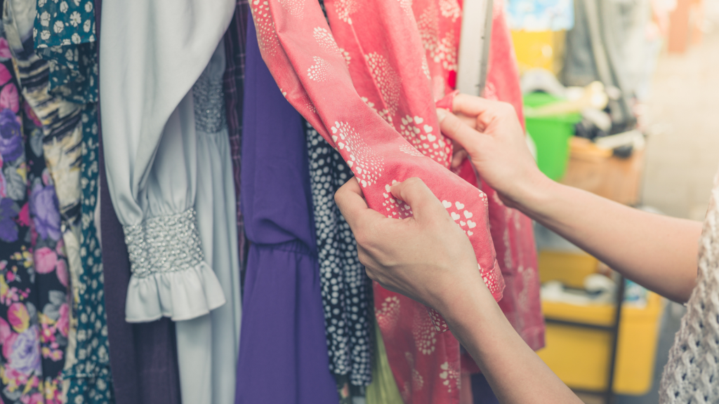 Mani toccano tessuto vestiti al mercato