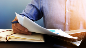 Persona al lavoro con fogli di carta