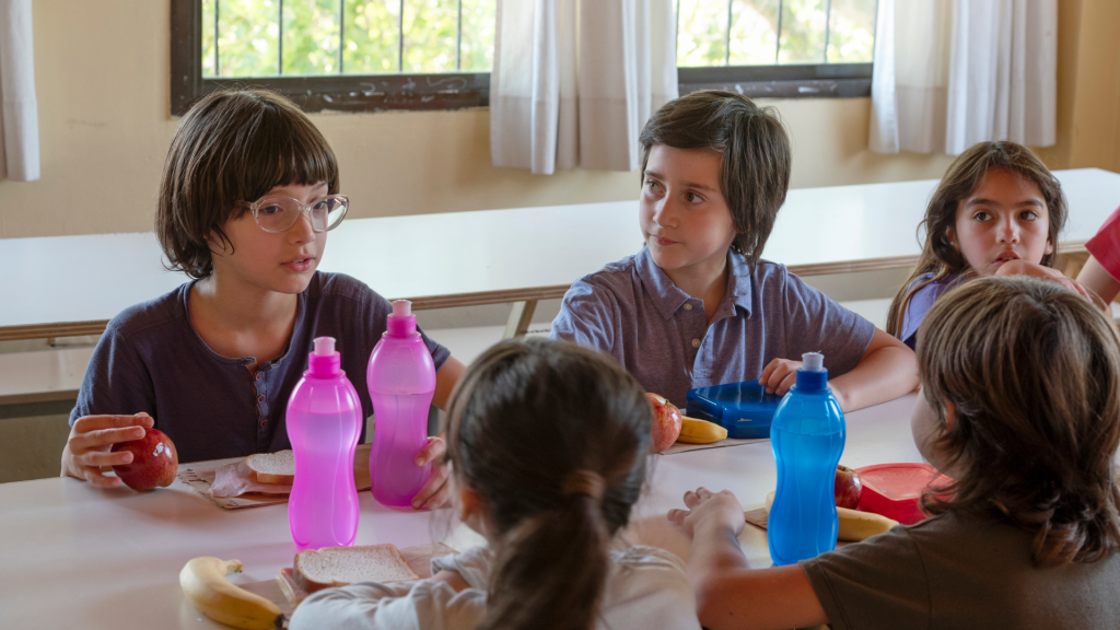Bambini al tavolo della mensa scolastica