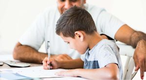 bambino che fa i compiti aiutato da un adulto