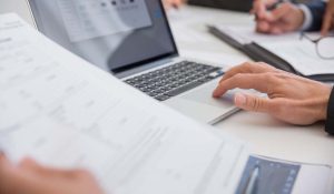 computer e mani che tengono dei fogli